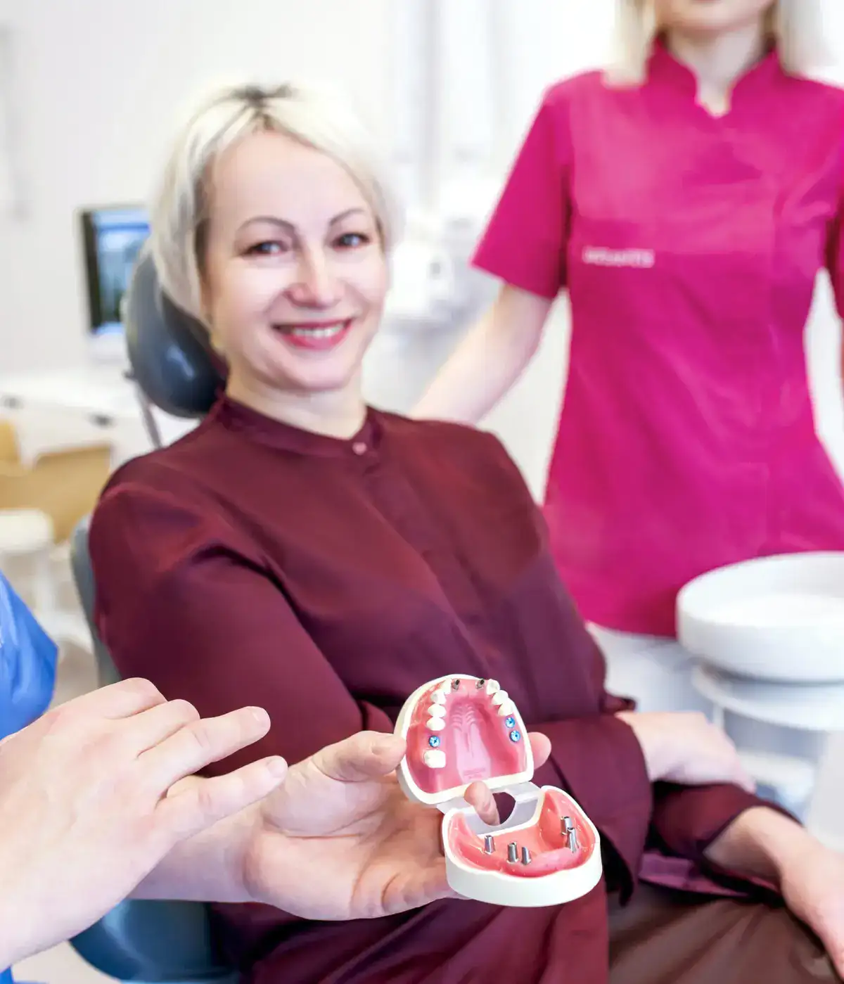 Uśmiechnięta kobieta w gabinecie Implantis Dentysta Kraków