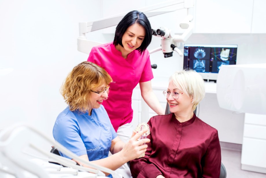 Dentystka Agata Heflich Sala pokazuje pacjentce model zębów.