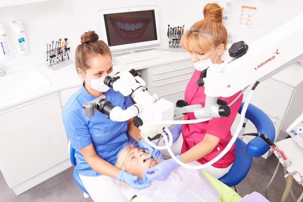 Leczenie kanałowe, doktor Magdalena Koralewicz wykonuje zabieg przy użyciu mikroskopu stomatologicznego